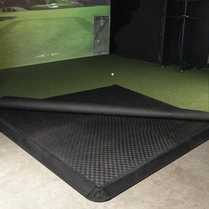 Carl's Golf Room Floor Tiles under turf in a simulator bay, turf rolled back
