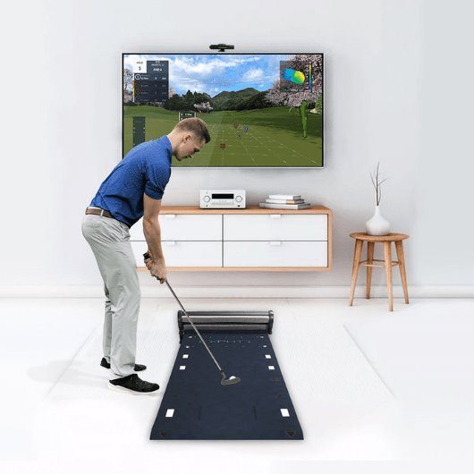 A golfer putting on an ExPutt mat with its camera on a TV stand