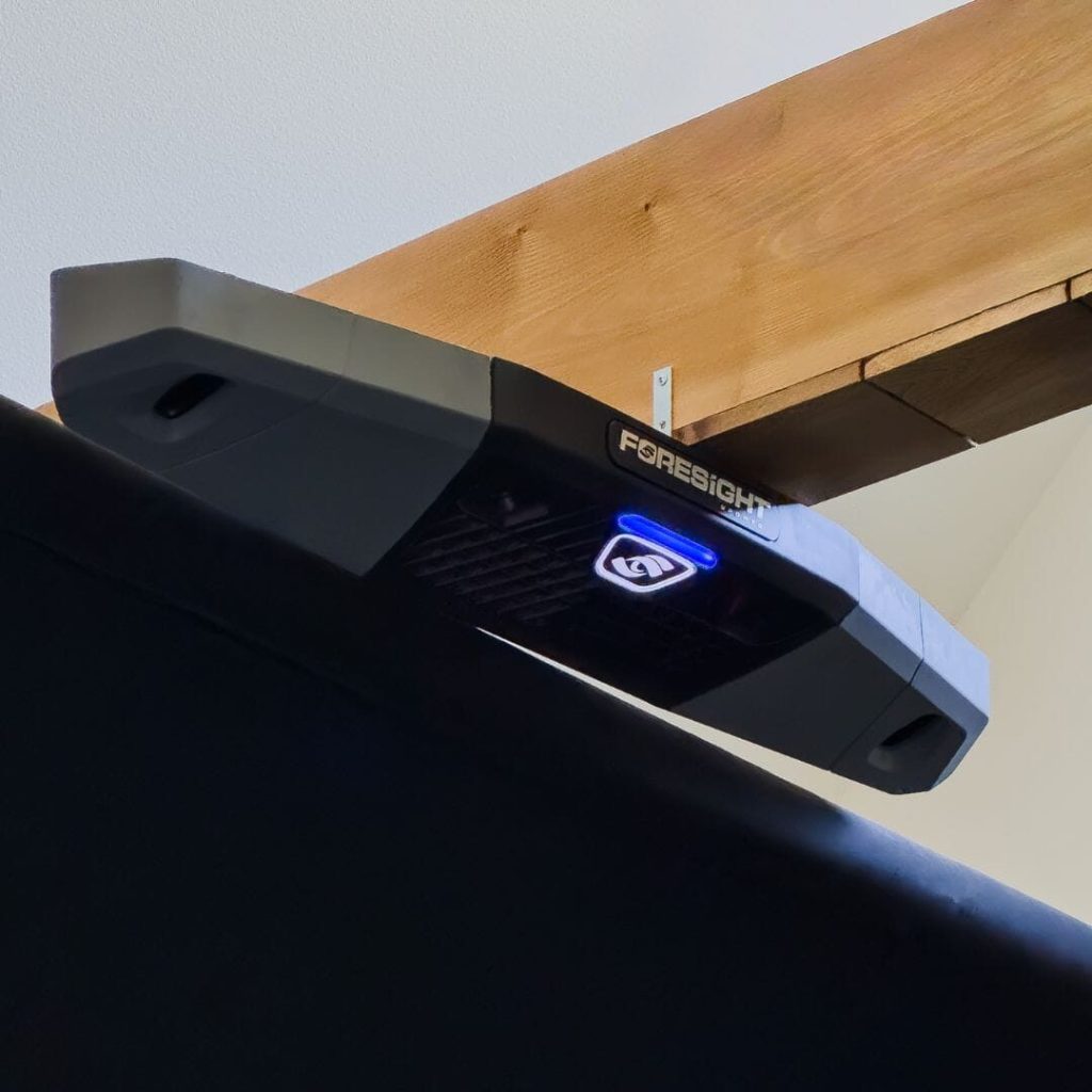 Foresight Falcon launch monitor mounted under a wooden ceiling beam
