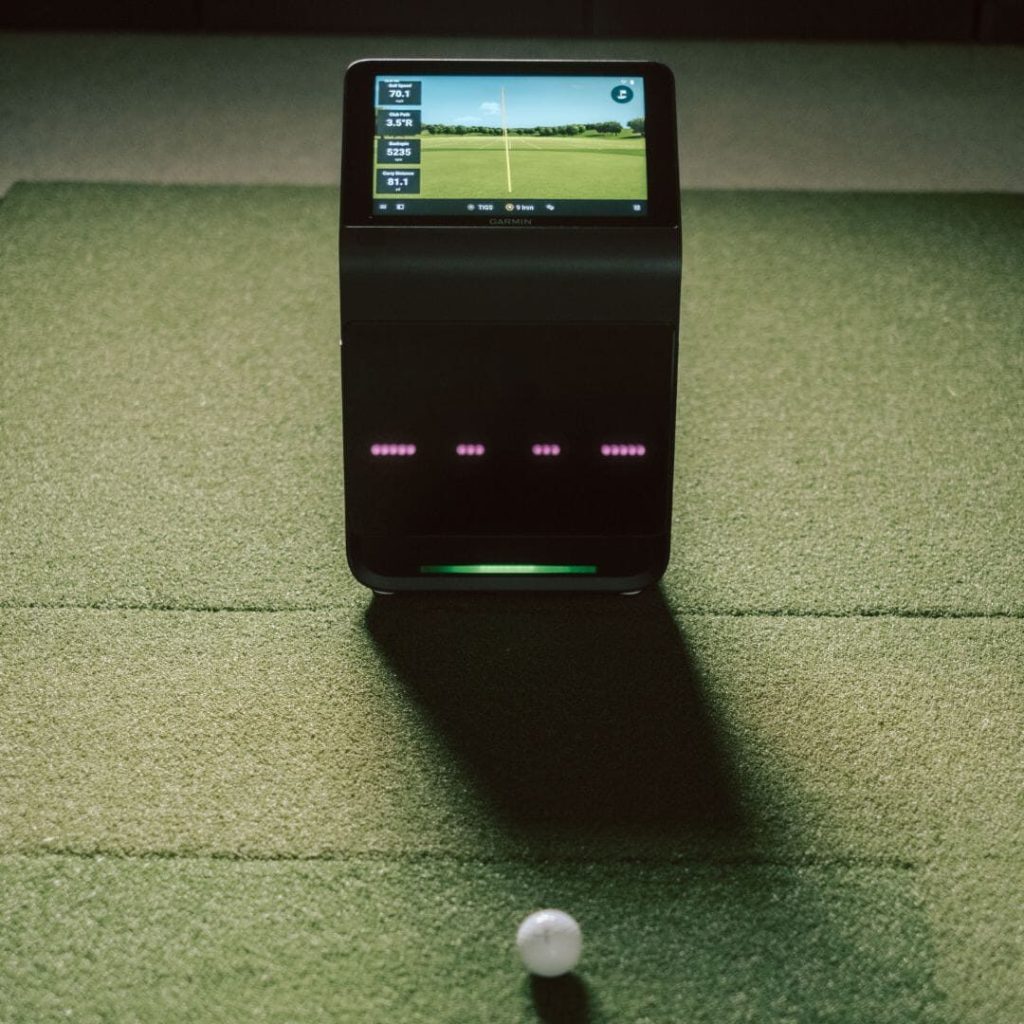 Most Accurate Launch Monitor (2026): What the Tests Show, and What "Accurate" Means Indoors 2 Garmin R50 launch monitor on turf beside a golf ball