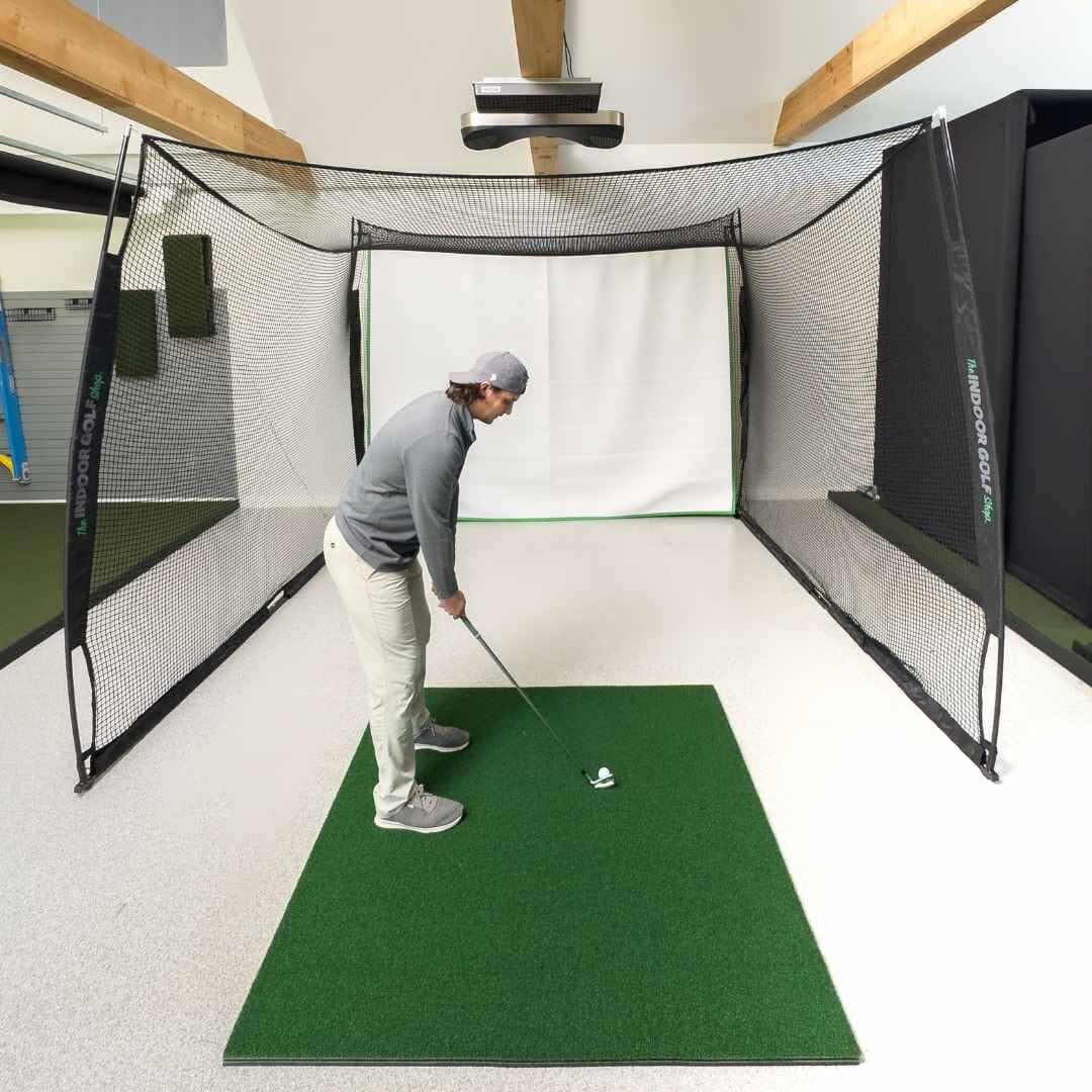 A golfer hitting into a 10 by 8 by 10 ft Square Golf net from a mat