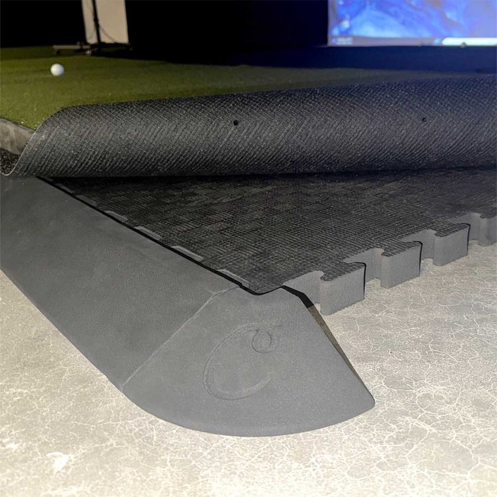 Golf Simulator Flooring (2026): What Goes Under and Around the Mat 3 A tapered edge piece at the edge of a floor-tile platform